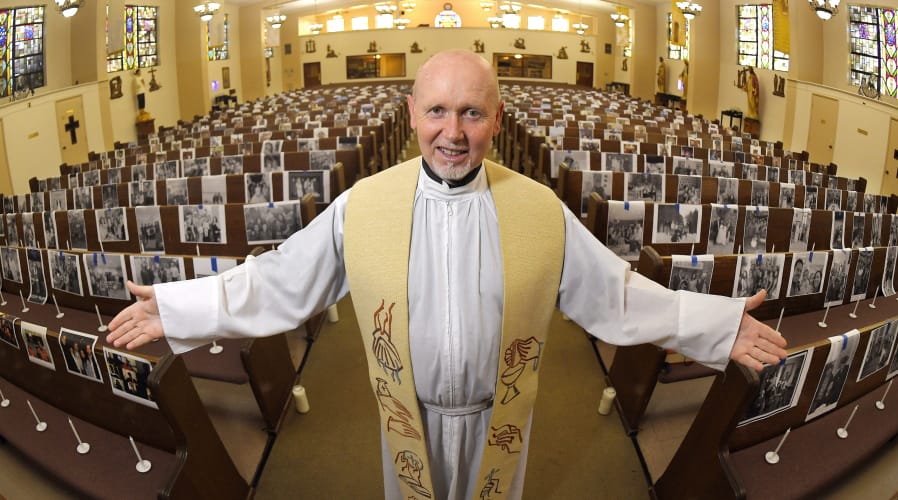 FILE - In this May 22, 2020, file photo, the Rev. Nicolas Sanchez Toledano poses among pews adorned with portraits of his parishioners at St. Patrick&#039;s Catholic Church during the coronavirus outbreak in the North Hollywood section of Los Angeles. California says churches can resume in-person services but the congregations will be limited to less than 100 and worshippers should wear masks, avoid sharing prayer books and skip the collection plate. The state Department of Public Health released a framework Monday, May 25, for county health officials to permit houses of worship to reopen.  (AP Photo/Mark J.