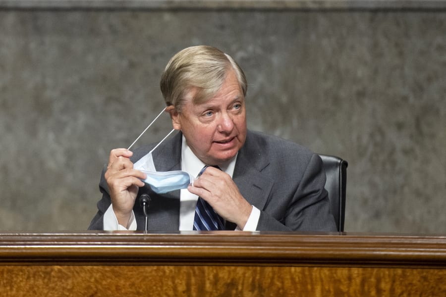 Chairman Lindsey Graham, R-S.C., takes off his mask as he arrives for the Senate Judiciary Committee hearing on &quot;Examining Liability During the COVID-19 Pandemic&quot; on Capitol Hill in Washington on Tuesday, May 12, 2020.