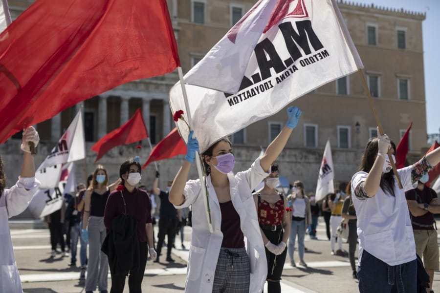 Protesters from the communist party-affiliated PAME union wearing masks to protect against coronavirus, march during a May Day rally outside the Greek Parliament, in Athens, on Friday, May 1, 2020. Hundreds of protesters gathered in central Athens and the northern Greek city of Thessaloniki to mark May Day, despite appeals from the government for May Day marches and commemorations to be postponed until next Saturday, when some lockdown measures will have been lifted.