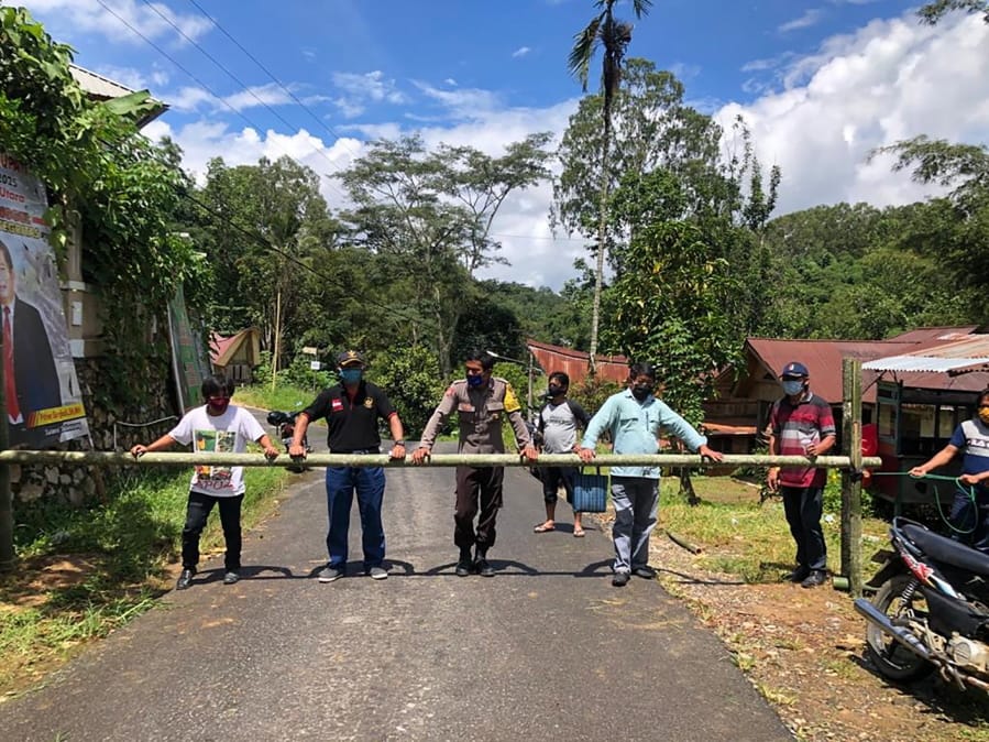 In this April 24, 2020, photo, provided by the Indigenous People Alliance of the Archipelago, indigenous peoples from the Buntao&#039; community in Indonesia&#039;s North Toraja regency in South Sulawesi Province use a wooden barrier to block off their village. Indigenous peoples across the archipelago are locking down their villages in an effort to protect their communities from the coronavirus.