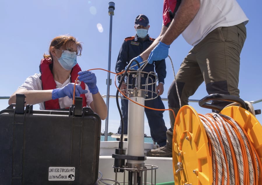 In this picture taken on Thursday, May 21, 2020, Italian Lazio region&#039;s environmental agency biologists Salvatore De Bonis, right, and Valentina Amorosi show how they perform tests on sea water during an interview with The Associated Press on a Coast Guard boat off Fiumicino, near Rome.
