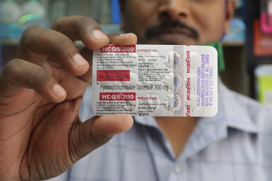 FILE - In this Tuesday, May 19, 2020 file photo, a chemist holds a pack of hydroxychloroquine tablets in Mumbai, India. A Friday, May 22, 2029 report in the journal Lancet shows malaria drugs pushed by U.S. President Donald Trump as treatments for the coronavirus not only did not help but were tied to a greater risk of death and heart rhythm problems in a study of nearly 100,000 patients around the world.