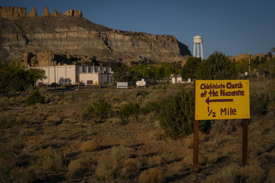 A hand-painted sign points the way to the Chilchinbeto Church of the Nazarene in Chilchinbeto, Ariz., on the Navajo reservation at sunrise on Sunday, April 19, 2020. The Navajo reservation has some of the highest rates of coronavirus in the country. If Navajos are susceptible to the virus&#039; spread in part because they are so closely knit, that&#039;s also how many believe they will beat it.