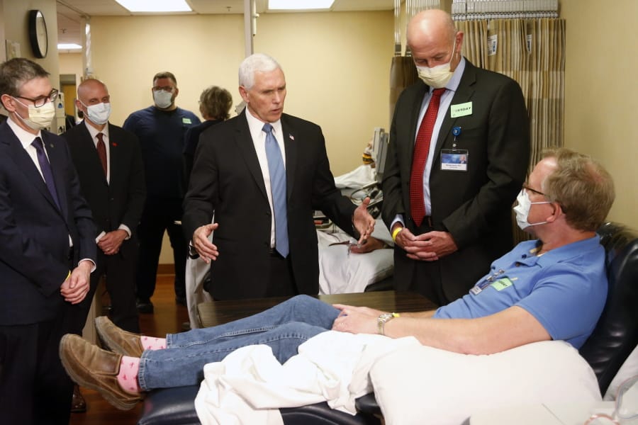 Vice President Mike Pence, center, visits Dennis Nelson, a patient who survived the coronavirus and was going to give blood, during a tour of the Mayo Clinic Tuesday, April 28, 2020, in Rochester, Minn., as he toured the facilities supporting COVID-19 research and treatment. Pence chose not to wear a face mask while touring the Mayo Clinic in Minnesota. It&#039;s an apparent violation of the world-renowned medical center&#039;s policy requiring them.