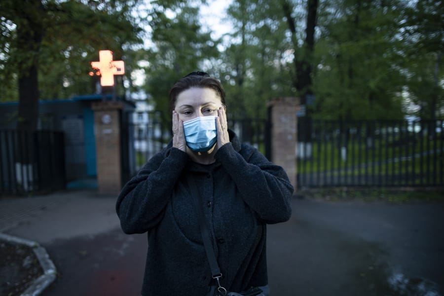 In this photo taken on Monday, May 18, 2020, Dr. Irina Vaskyanina adjusts a face mask to protect against coronavirus during her interview with the Associated Press in front of a hospital in Reutov, just outside Moscow, Russia. Vaskyanina headed a department handling blood transfusions at a hospital in Reutov, outside Moscow, and spent weeks fighting for better working conditions after 40 of her colleagues got infected with the virus and dozens quit.