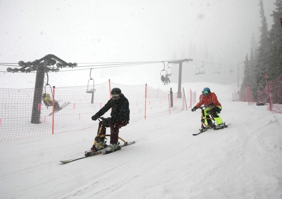 FILE - In this April 10, 2019, file photo, riders on ski-bikes participating in the 30th Annual Enduro, a fundraiser and ski-a-thon to benefit a local cause, heads towards base of Pallavicini Chair at Arapahoe Basin Ski Area, Colo. The ski resort will open for limited spring skiing and riding on Wednesday, May 27, 2020. This follows approval of Summit County&#039;s request for a variance from the state public health order by the Colorado Department of Public Health and Environment. At this time, closing day is still to be determined.