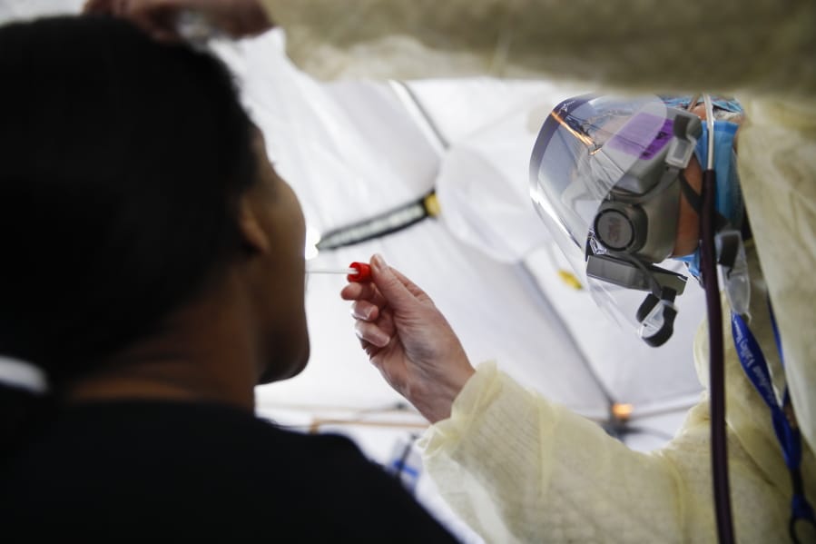 FILE - In this April 20, 2020, photo, a test is performed on a patient in a COVID-19 triage tent at St. Joseph&#039;s Hospital in Yonkers, N.Y. An Associated Press analysis finds that most states are not meeting the minimum levels of testing suggested by the federal government and recommended by public health researchers even as many of them begin to reopen their shattered economies.