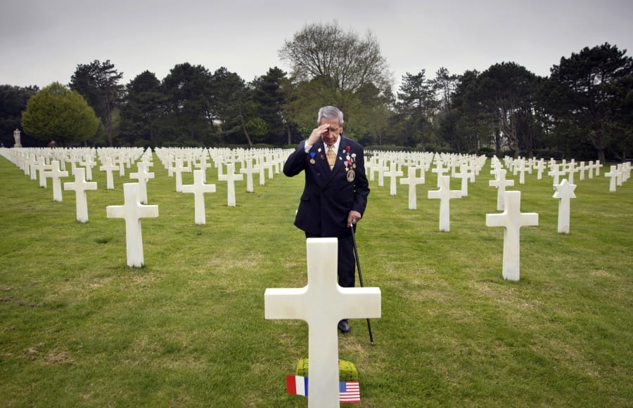 In this May 1, 2019 file photo, World War II and D-Day veteran Charles Norman Shay, from Indian Island, Maine, salutes the grave of fellow soldier Edward Morozewicz at the Normandy American Cemetery in Colleville-sur-Mer, Normandy, France. Instead of parades, remembrances, embraces and one last great hurrah for veteran soldiers who are mostly in their nineties to celebrate VE Day, it is instead a lockdown due to the coronavirus, COVID-19.