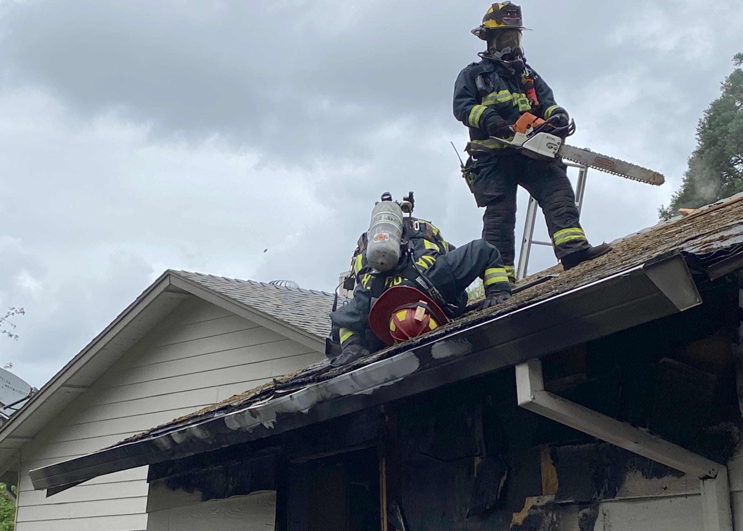 Vancouver Fire Department firefighters inspect the attic space of a garage that caught fire Monday.