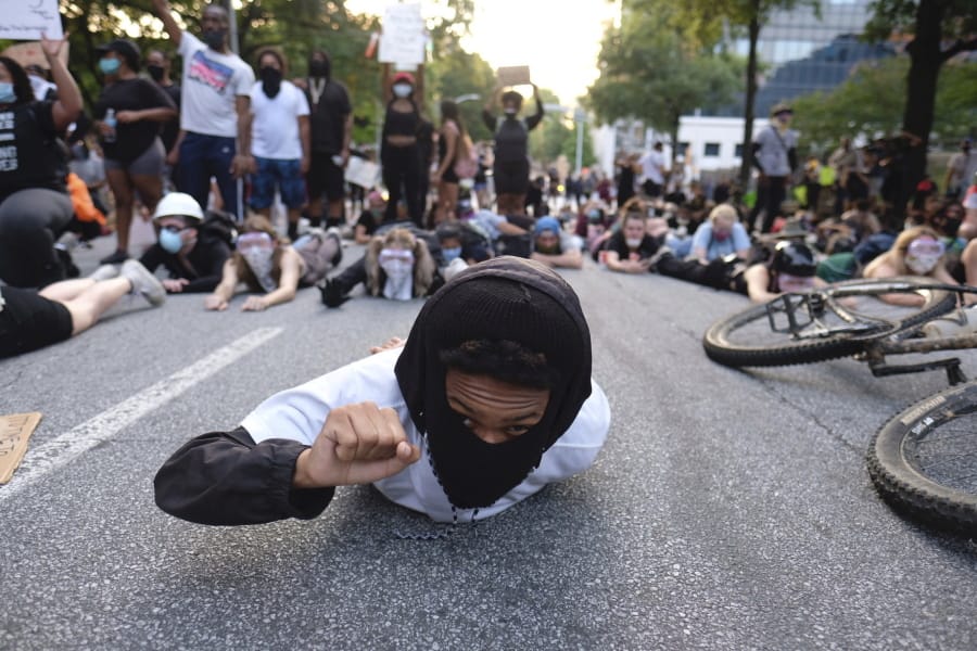 Protesters lie on a street during a demonstration Monday, June 1, 2020, in Atlanta over the death of George Floyd, who died May 25 in Minneapolis.