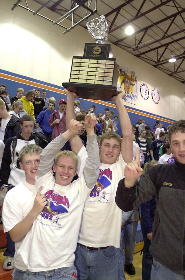 Ridgefield baseball players (from left) Jamie Kaneen, Stu Draper, Jon Parnell, and Joel Fern, celebrate their 2002 state champion during a school assembly.