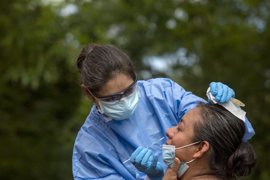Blanca Haladyna, of Chesapeake Regional Healthcare, prepares to do a COVID-19 nasal-swab test on Juana San Juan, of Newport News, at Geneva Square in Chesapeake on Friday, June 5, 2020.