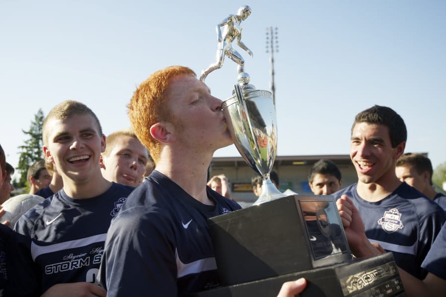 Skyview's Hayden Schuh, center, kisses the 4A state soccer championship trophy after the Storm beat Central Kitsap 3-2 on May 26, 2012.