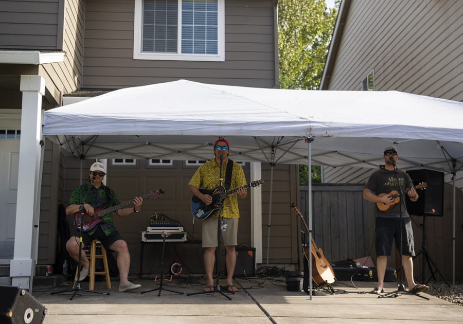 Randy Chang, left, Kaloku Holt, center, and Kaleo Titcomb, right, perform Hawaiian-style music in a driveway concert for Holt&#039;s Whipple Creek neighborhood on a recent Friday night.