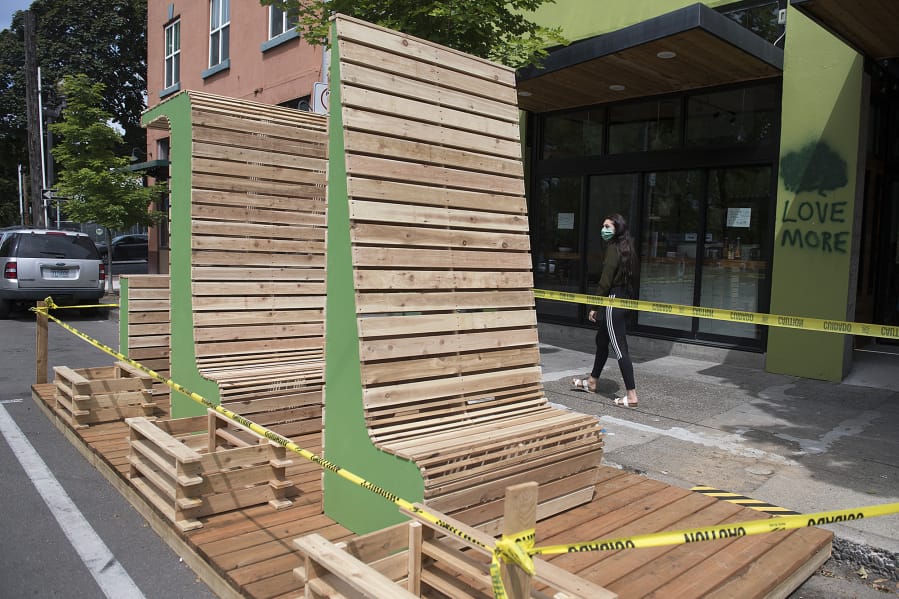 Vancouver resident Natany Reid checks out parklet seating under construction for guests outside The Mighty Bowl in downtown Vancouver on Tuesday morning. The popular restaurant is the first to build outdoor seating of this kind for customers.