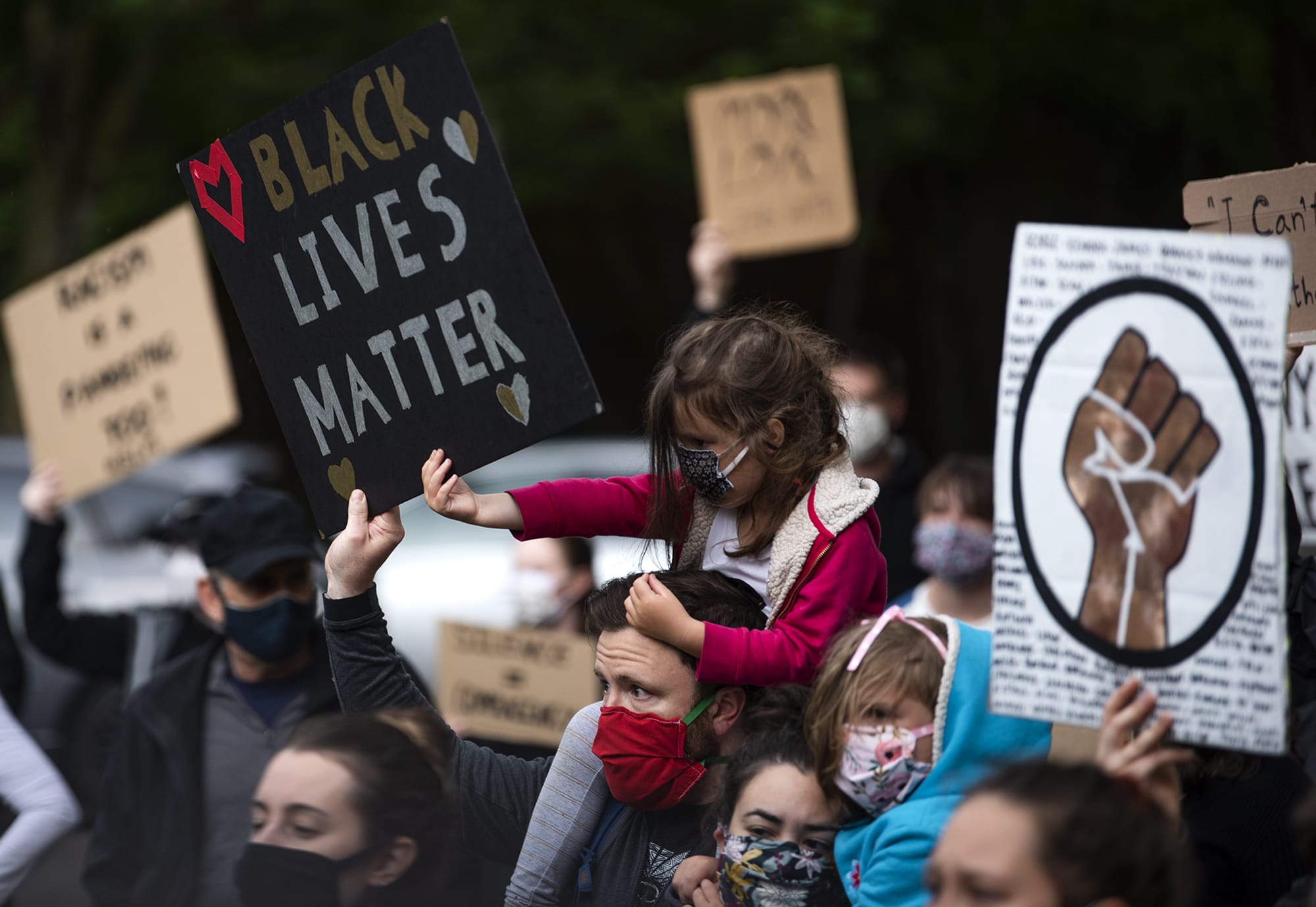 Clementine Tomerlin of Vancouver, 5, helps her dad, Clay, hold up a sign as they join hundreds of people for a peaceful protest against police brutality outside Clark County Courthouse in Vancouver on June 5, 2020.