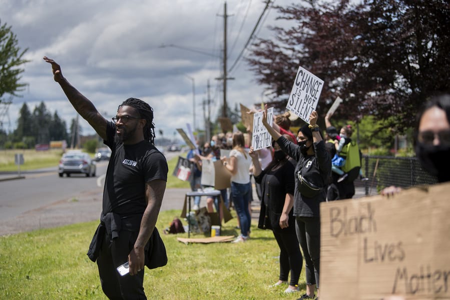 Matthew Young of Vancouver Elite Outreach, left, joins fellow demonstrators Wednesday as they rallied for black lives outside Evergreen High School.