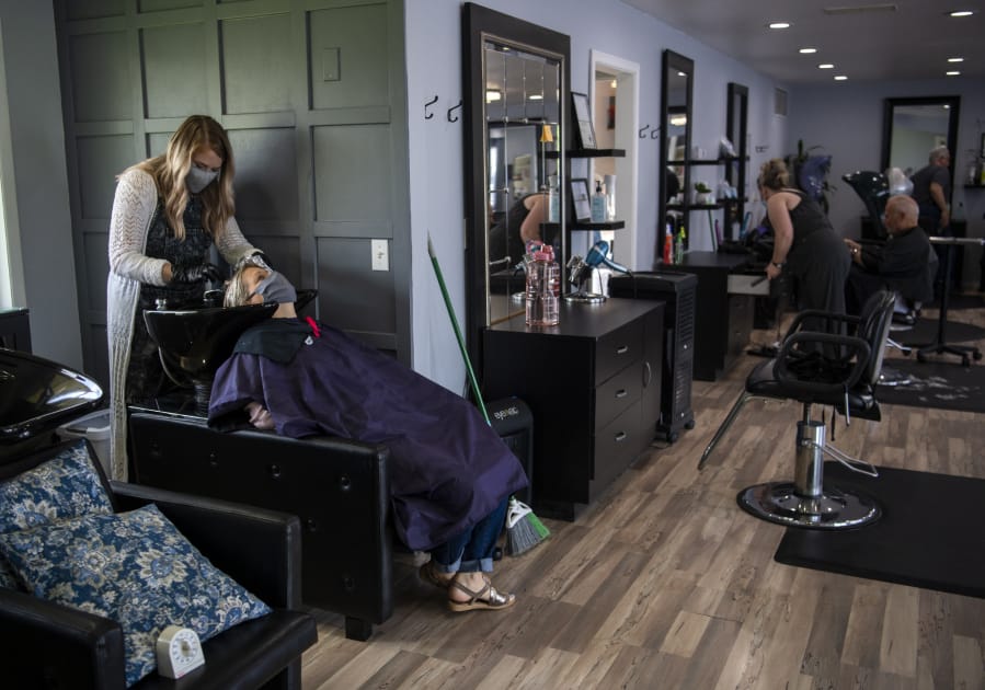 Devin McFeron, 27, works with client Tyra Squires at Finesse Beauty Bar in Battle Ground on June 11. McFeron, a stylist, welcomed her first client back on June 8, after being unemployed since March because of the pandemic.