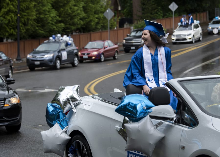 La Center High School graduate Dayna Hines rides through the car parade graduation celebration in La Center on Saturday. In lieu of an in-person ceremony, students participated in a parade through the city. The COVID-19 pandemic forced the cancellation or delay of graduation events across the state, but schools are finding creative ways to celebrate their students.