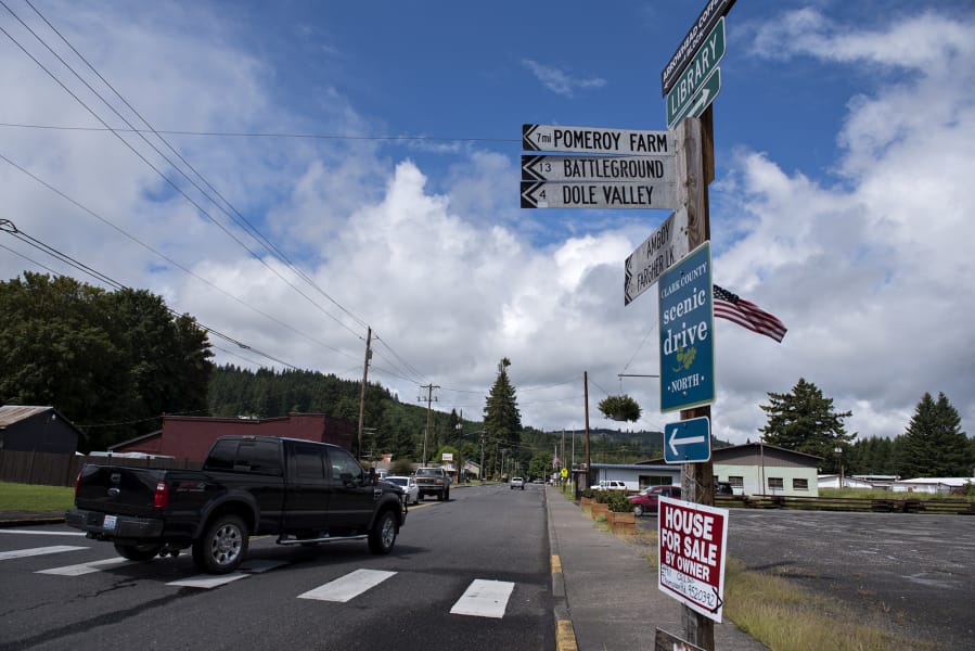 A motorist drives through downtown Yacolt as signs point the way to nearby towns and areas of interest.