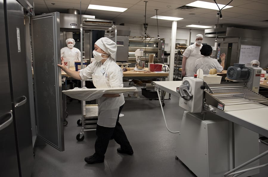 First-year bakery student Anna Ostapa, foreground, joins classmates as she learns to make turnovers and palmiers at Clark College on Wednesday morning, June 24, 2020. Students were making up a lab they were unable to complete in the spring because of COVID-19 concerns.