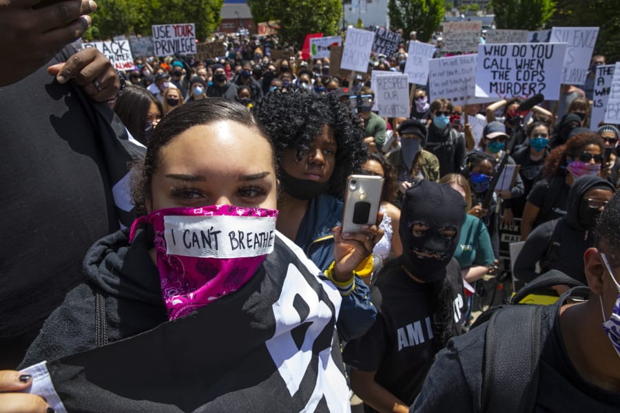 A young woman with the words &quot;I can&#039;t breathe&quot; on her face covering joins thousands at a Black Lives Matter event in Eugene, Ore., Sunday May 31, 2020, over the deaths of George Floyd and others (Chris Pietsch/The Register-Guard via AP)