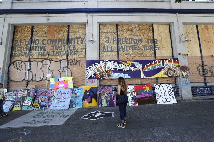 Plywood and artwork cover a wall on a closed police precinct Thursday, June 18, 2020, in Seattle, in what has been named the Capitol Hill Occupied Protest zone. Police pulled back from several blocks of the city&#039;s Capitol Hill neighborhood near the police department&#039;s East Precinct building earlier in the month after clashes with people protesting the death of George Floyd in Minneapolis.