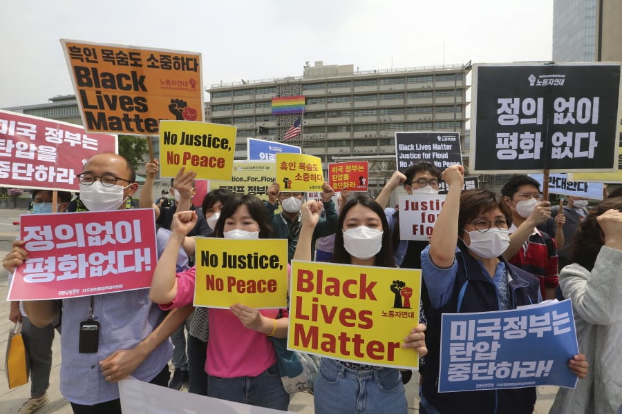 South Korean protesters shout slogans during a protest over the death of George Floyd, a black man who died after being restrained by Minneapolis police officers on May 25, near the U.S. embassy in Seoul, South Korea, Friday, June 5, 2020. The signs read &quot;The U.S.