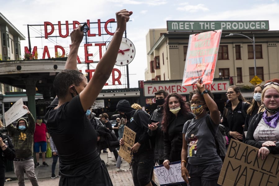 Protesters continue past Pike Place Market during the #SeattleJusticeForGeorgeFloyd march on Saturday, June 6, 2020, in Seattle, Washington. The death of George Floyd at the hands of police last month in Minneapolis has sparked nationwide protests for police reform.