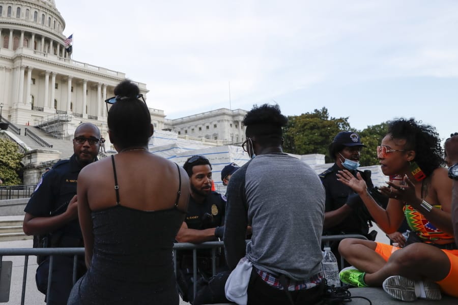 U.S. Capitol police officers talk with demonstrators as they have a conversation about racism in America as they protest the death of George Floyd, Wednesday, June 3, 2020, on Capitol Hill in Washington. Floyd died after being restrained by Minneapolis police officers. At right is Lydia Robinson, 31, of Raleigh, N.C.