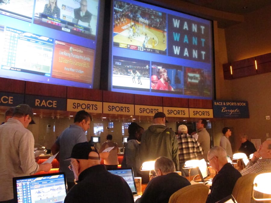 FILE - In this March 21, 2019 file photo, gamblers line up to place bets on the NCAA men&#039;s basketball tournament at the Borgata casino in Atlantic City N.J. After being closed since March due to the coronavirus outbreak, the Borgata will reopen to the general public on July 6, 2020, four days after much of its competition. Instead, the casino will be doing a test run for an invitation-only audience during those four days.