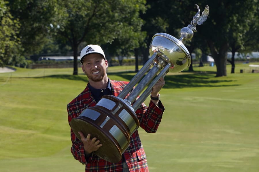 Daniel Berger poses with the championship trophy after winning the Charles Schwab Challenge golf tournament after a playoff round at the Colonial Country Club in Fort Worth, Texas, Sunday, June 14, 2020. (AP Photo/David J.