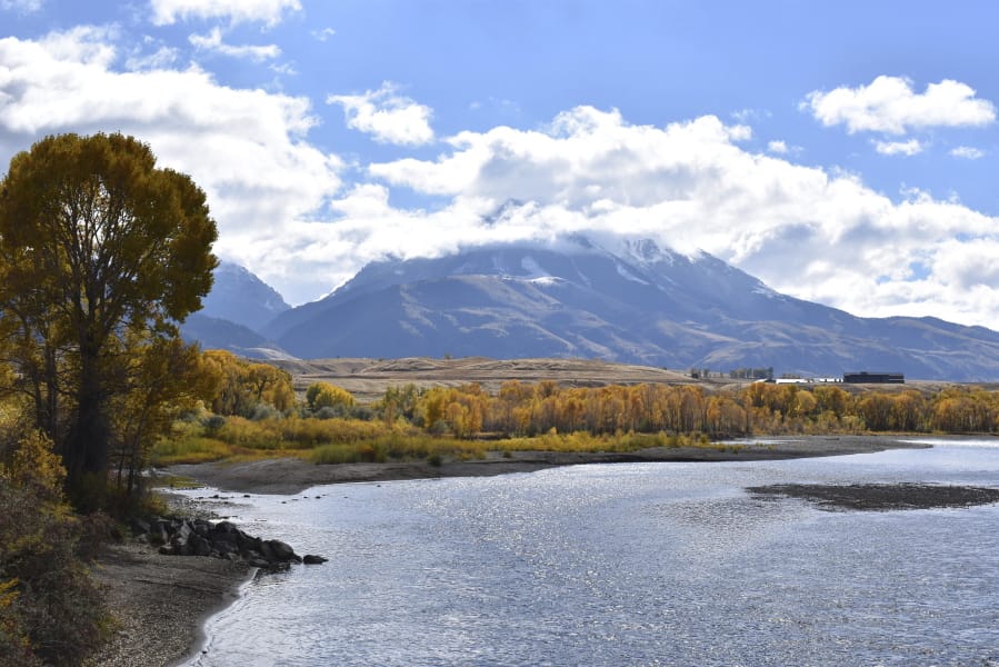 FILE - In this Oct. 8, 2018 file photo, emigrant Peak is seen rising above the Paradise Valley and the Yellowstone River near Emigrant, Mont. Lawmakers have reached bipartisan agreement on an election-year deal to double spending on a popular conservation program and devote nearly $2 billion a year to improve and maintain national parks.