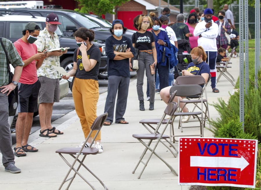 Voters wait in a line that stretched around the Metropolitan Library in Atlanta, Georgia, Tuesday, June 9, 2020.