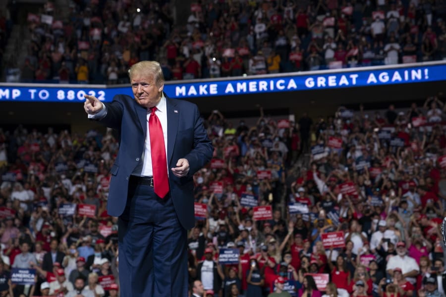 In this June 20, 2020, photo, President Donald Trump arrives on stage to speak at a campaign rally at the BOK Center in Tulsa, Okla.