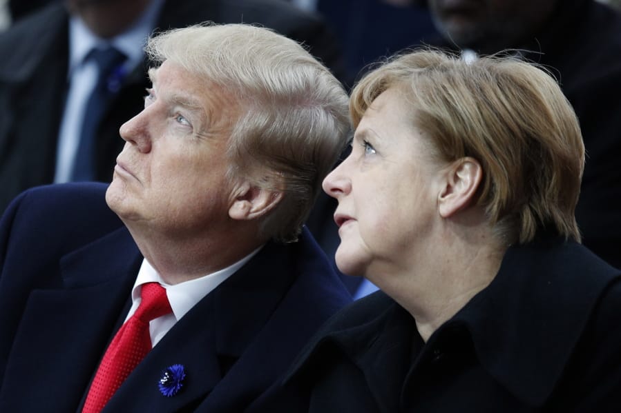 FILE - In this Sunday, Nov. 11, 2018 file photo, U.S President Donald Trump and German Chancellor Angela Merkel attend ceremonies at the Arc de Triumphe in Paris. After more than a year of thinly veiled threats that the United States could start pulling troops out of Germany unless the country increases its defense spending to NATO standards, President Donald Trump appears to be going ahead with the hardball approach with a plan to reduce the American military presence in the country by more than 25 percent.