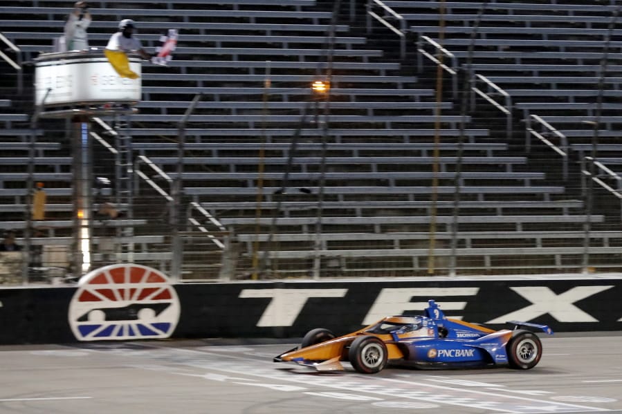 Scott Dixon earns the checkered flag as he crosses the finish line to win an IndyCar auto race at Texas Motor Speedway in Fort Worth, Texas, Saturday, June 6, 2020.
