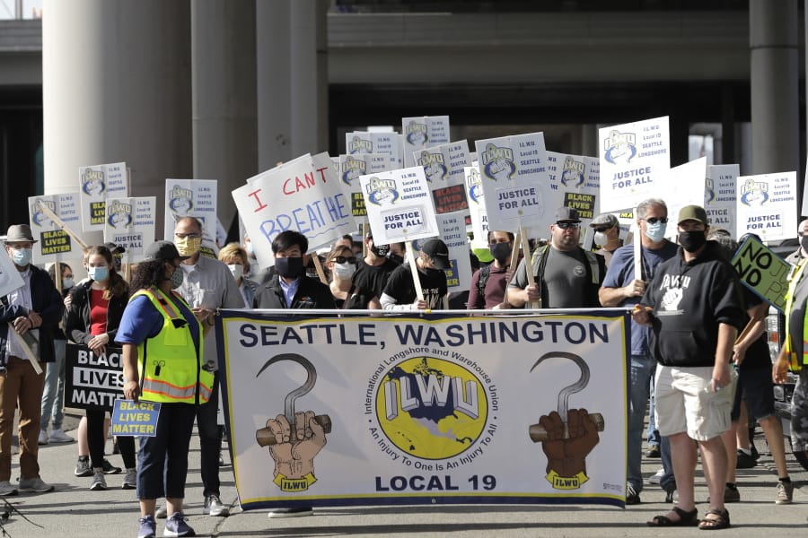 Union workers and other supporters march Friday, June 19, 2020, near the Port of Seattle as part of a coordinated eight-hour work stoppage at more than two dozen West Coast Ports that was organized by the International Longshore and Warehouse Union. Workers took part in rallies honoring Juneteenth and to protest against police violence and racism. (AP Photo/Ted S. Warren) (ted s.