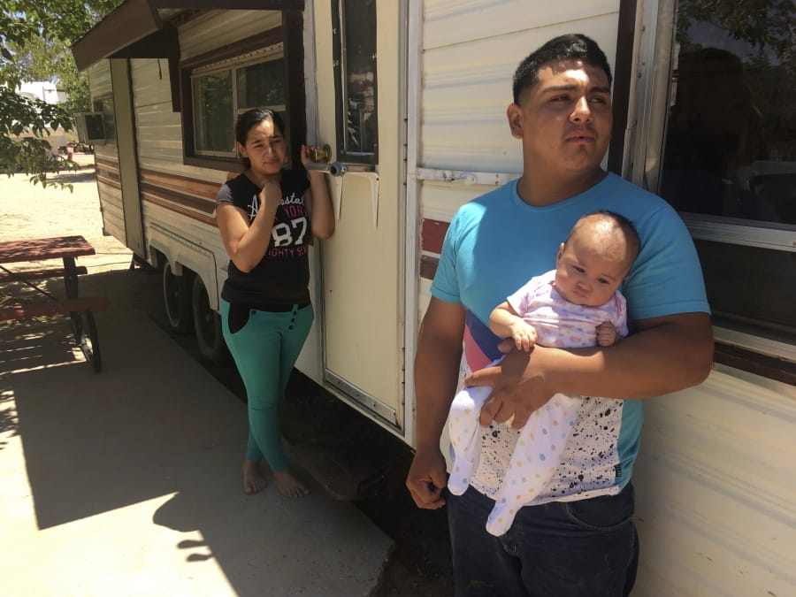 FILE - In this May 25, 2018, file photo, Jose Espinoza, 18, stands outside his trailer with his 4-month-old infant, Emmily, and wife, Maria Rodriguez, 19, in Vado, N.M. while speaking about making only $50 a day picking onions. New Mexico&#039;s child poverty rate rose slightly and continues to rank near the bottom nationally despite improvements in the state&#039;s economy, a child-advocacy group said Wednesday, Jan. 15, 2020. The 2019 New Mexico Kids Count Data Book, released by New Mexico Voices for Children, found 26% of the state&#039;s children in 2018 remained at or below the federal poverty line. That places the state back to 49th nationally in child poverty.