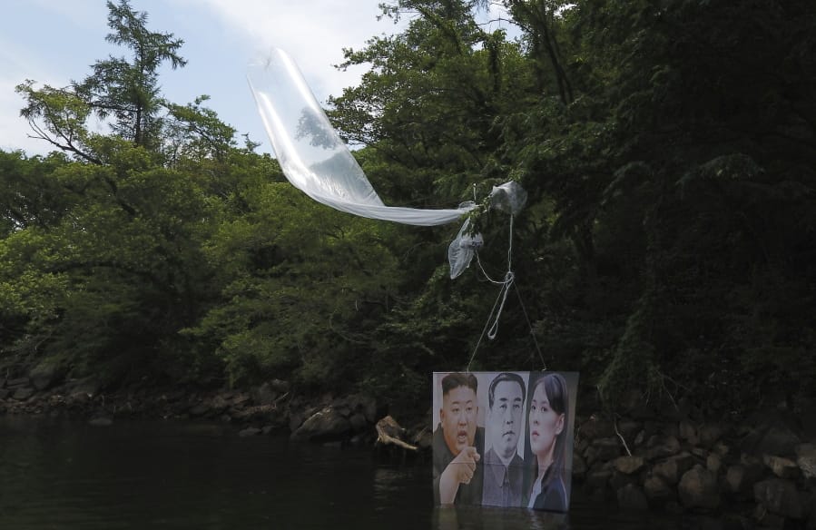 A balloon carrying a banner with images of North Korean leader Kim Jong Un, left, the late leader Kim Il Sung, center, and Kim Yo Jong, the powerful sister of Kim Jong Un, released by Fighters For Free North Korea, is seen in Hongcheon, South Korea, Tuesday, June 23, 2020. A South Korean activist said Tuesday hundreds of thousands of leaflets had been launched by balloon across the border with North Korea overnight, after the North repeatedly warned it would retaliate against such actions.
