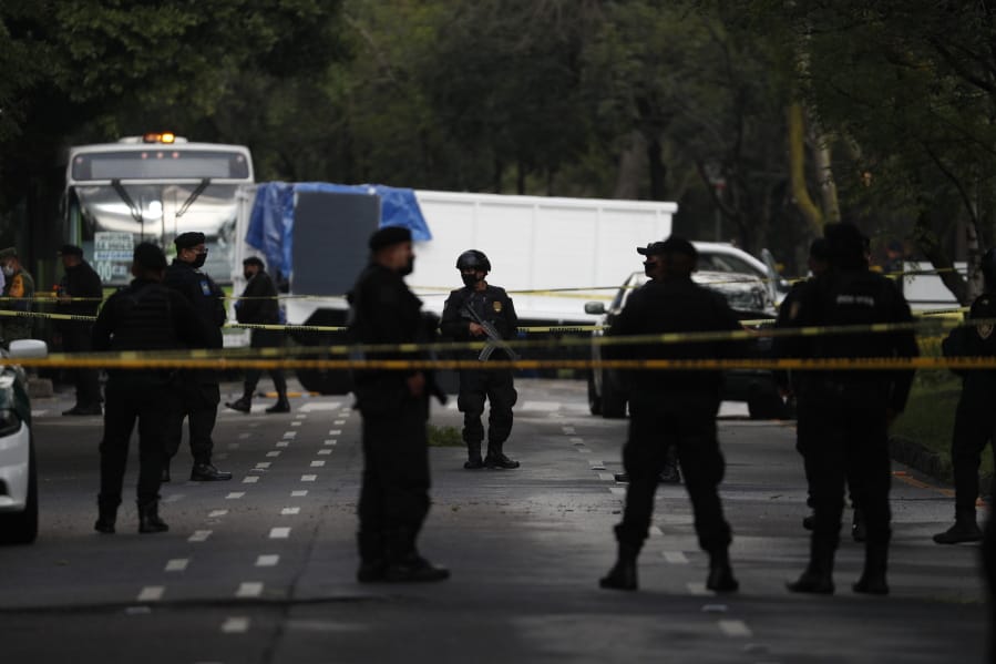 Police stand guard at a crime scene where the chief of police was attacked by gunmen in the early morning hours, in Mexico City, Friday, June 26, 2020.  Heavily armed gunmen attacked and wounded Omar Garcia Harfuch in a brazen operation that left an unspecified number of dead, Mayor Claudia Sheinbaum said Friday.