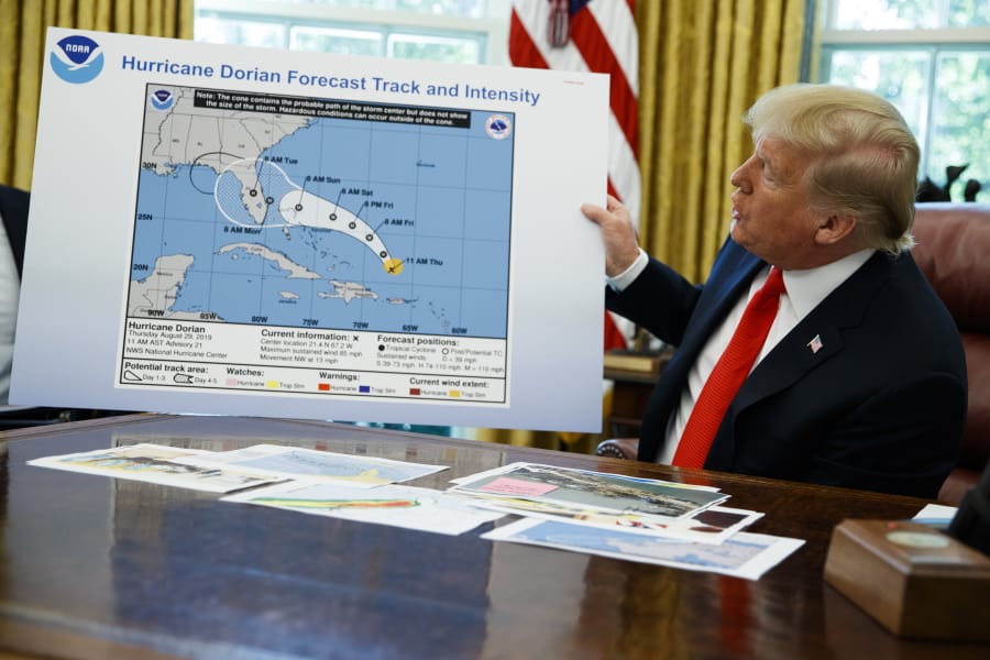 President Donald Trump holds a chart as he talks Sept. 4, 2019, with reporters after receiving a briefing on Hurricane Dorian in the Oval Office in the White House in Washington.