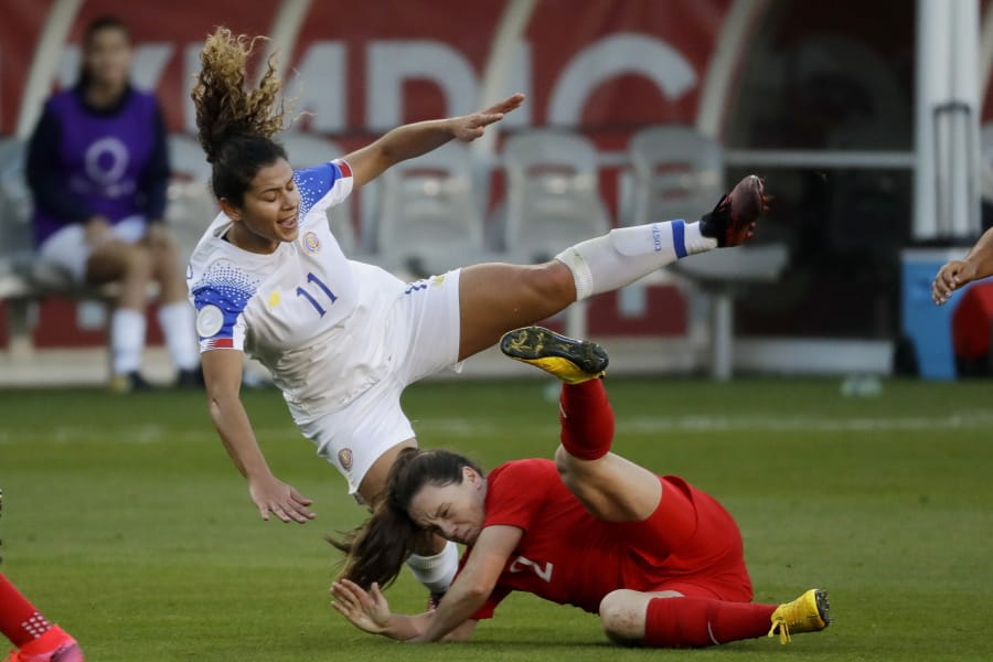 FILE - In this Feb. 7, 2020, file photo, Costa Rica forward Raquel Rodriguez, top, is knocked over by Canada defender Allysha Chapman during the first half of a CONCACAF women&#039;s Olympic qualifying soccer match in Carson, Calif. Raquel Rodriguez, better known as Rocky to her fans, was in route to join her new National Women&#039;s Soccer League team when sports were shut down by the coronavirus.  It certainly wasn&#039;t an ideal start for the Costa Rican striker with the Portland Thorns.