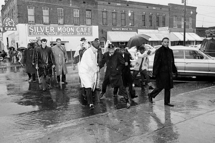 FILE - In this March 1, 1965 file photo Dr. Martin Luther King Jr. hops over a puddle as it rains in Selma, Ala. King led hundreds of African Americans to the court house in a voter registration drive. At front is civil rights worker Andrew Young, and at right, behind King is Rev. Ralph Abernathy. Today&#039;s protests across America against racial injustice are being watched closely by people who five decades ago faced jail cells, bloody assaults, snarling dogs and even potential assassination in the battle against institutional racism. Young, a King lieutenant, marvels at both the sizes and the spontaneity of the protests. The former Democratic congressman, Atlanta mayor and United Nations ambassador recalled activists spending three months to organize for a 1963 Birmingham, Alabama, campaign in which King and other protesters were jailed.