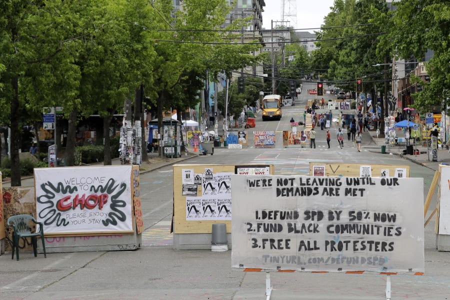 A sign on the street welcomes visitors and a list of demands is posted Wednesday, June 24, 2020, inside the CHOP (Capitol Hill Occupied Protest) zone in Seattle. The area has been occupied since a police station was largely abandoned after clashes with protesters, but Seattle Mayor Jenny Durkan said Monday that the city would move to wind down the protest zone following several nearby shootings and other incidents that have distracted from changes sought peaceful protesters opposing racial inequity and police brutality. (AP Photo/Ted S.