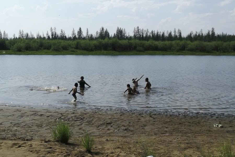 In this handout photo provided by Olga Burtseva, children play in the Krugloe lake outside Verkhoyansk, the Sakha Republic, about 4660 kilometers (2900 miles) northeast of Moscow, Russia, Sunday, June 21, 2020. A Siberian town that endures the world&#039;s widest temperature range has recorded a new high amid a hear wave that is contributing to severe forest fires. Russia&#039;s meteorological service said the thermometer hit 38 Celsius (100.4 F) on Saturday in Verkhoyansk, in the Sakha Republic about 4660 kilometers (2900 miles) northeast of Moscow.