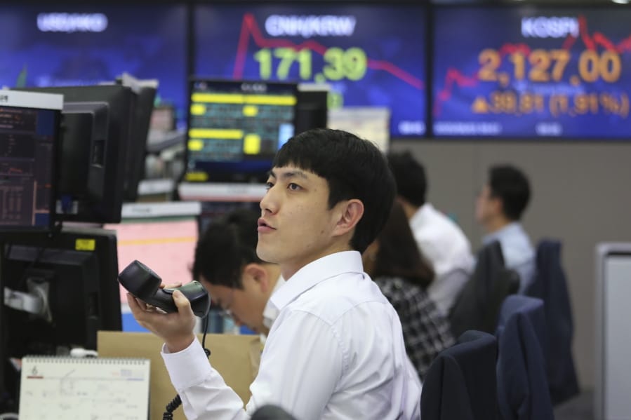 A currency trader watches monitors at the foreign exchange dealing room of the KEB Hana Bank headquarters in Seoul, South Korea, Wednesday, June 3, 2020. Asian shares are rising after Wall Street extended its gains for the third straight day, driven by optimism over economies reopening from shutdowns to stem the coronavirus pandemic.