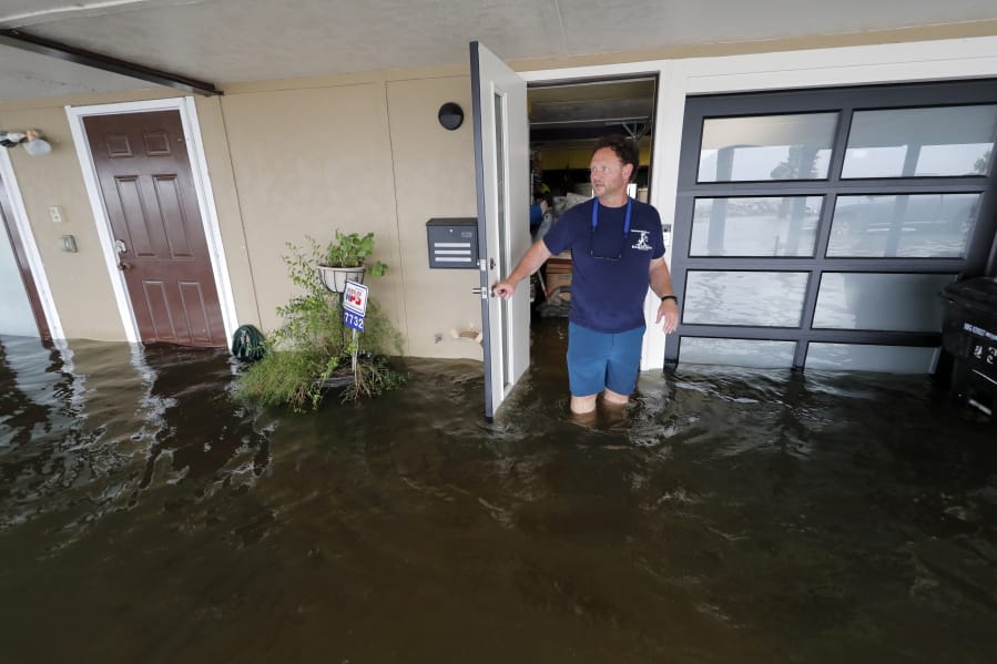 Rudy Horvath walks out of his home, a boathouse in the West End section of New Orleans, as it takes on water a from storm surge in Lake Pontchartrain in advance of Tropical Storm Cristobal, Sunday, June 7, 2020.
