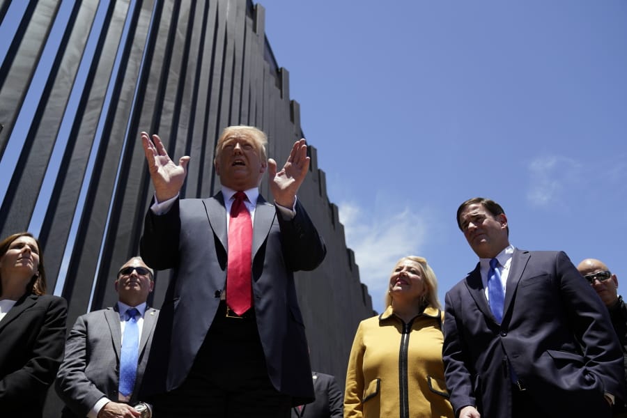 President Donald Trump speaks as he tours a section of the border wall, Tuesday, June 23, 2020, in San Luis, Ariz. Arizona Gov. Doug Ducey, second from right, and Rep. Debbie Lesko, R-Ariz., third from right.