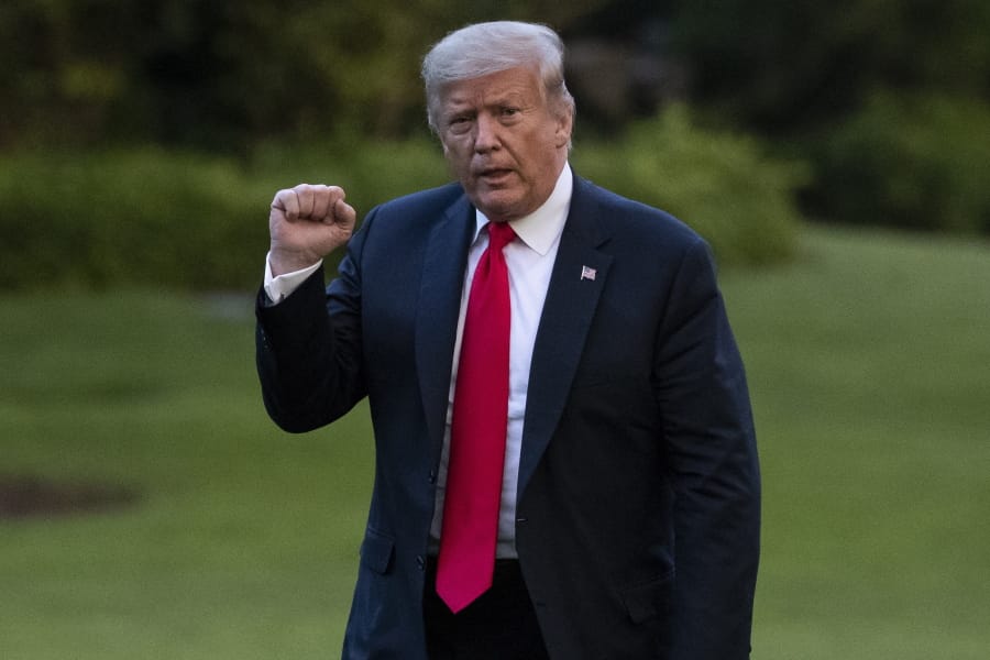 President Donald Trump pumps his fist as he walks on the South Lawn after arriving on Marine One at the White House, Thursday, June 25, 2020, in Washington. Trump is returning from Wisconsin.